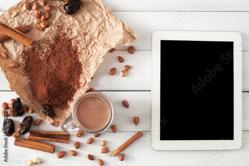 Chocolate smoothie ingredients on white wood with tablet screen