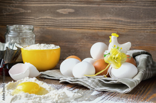 Fresh chicken eggs kitchen wooden table for making a festive Easter cake, dark background photo