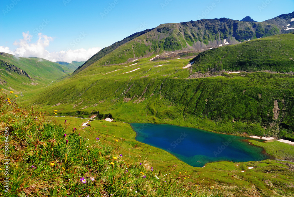 Mountain Lake in the Caucasus summer. Blue sky with white clouds.