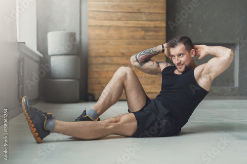 Young man fitness workout, cross crunches for abs
