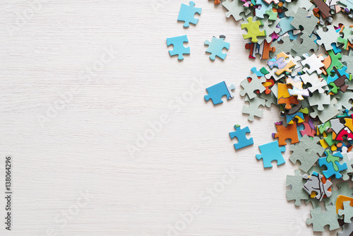 Puzzle pieces on a white wooden surface closeup.