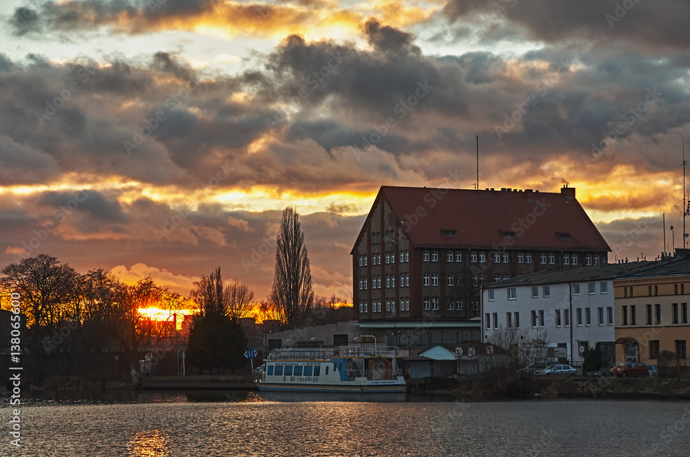 A fiery sunset over the river in the city.