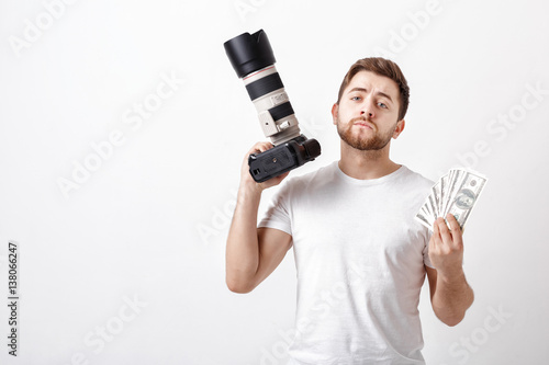 young handsome photographer with beard in shirt holding camera a