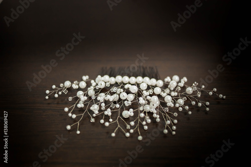 wedding decoration for hair comb in white beads and beaded close-up black brown wooden background copyspace