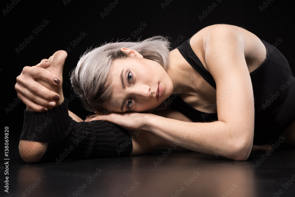 Attractive sporty young woman dancer stretching and looking at camera Attractive sporty young woman dancer stretching and looking at camera