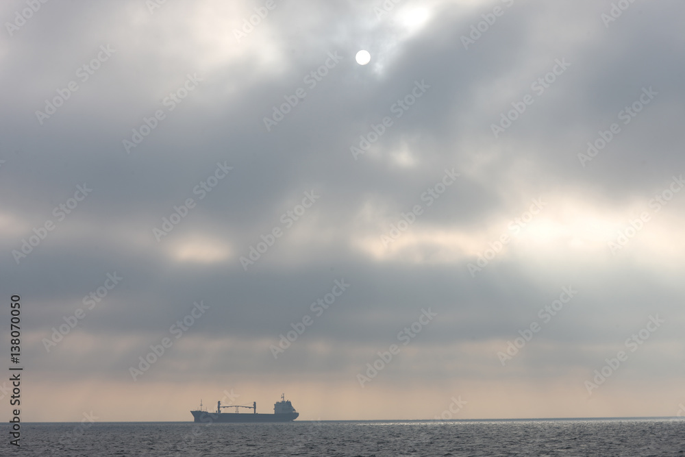 Obraz premium The ship anchored in the waters of the Gulf of Riga of the Baltic Sea in anticipation of a pilot