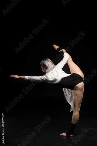 back view of woman in bodysuit dancing on black