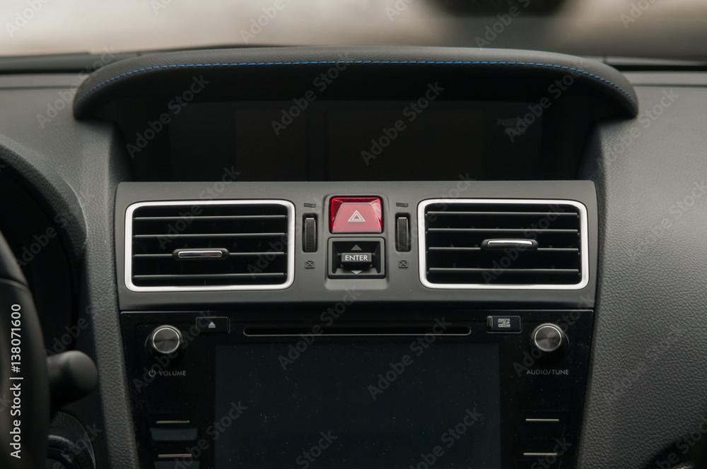 Display, climate control and air vents in the car.