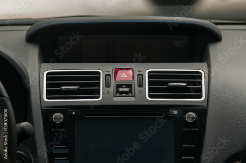 Display, climate control and air vents in the car.