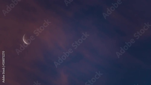Crescent moon and clouds flowing at dawn
