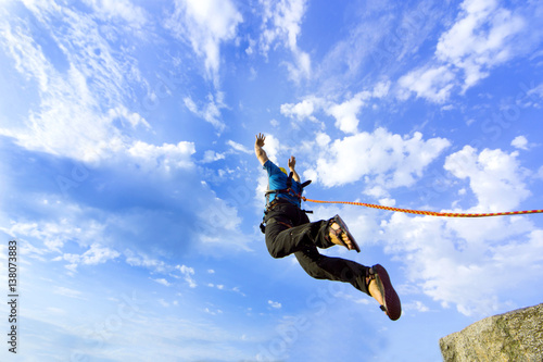 Fotografía Jump rope from a high rock in the mountains.