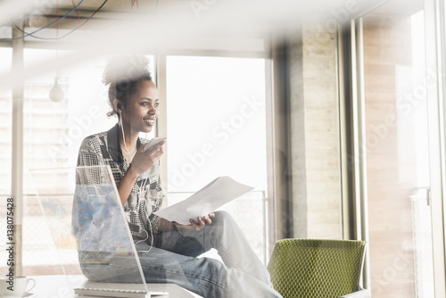 Young woman working in office using transparent computer