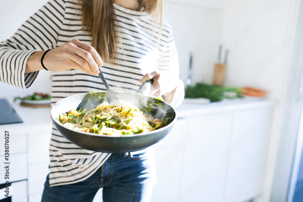 Young woman holding pan with vegan pasta dish Young woman holding pan with vegan pasta dish