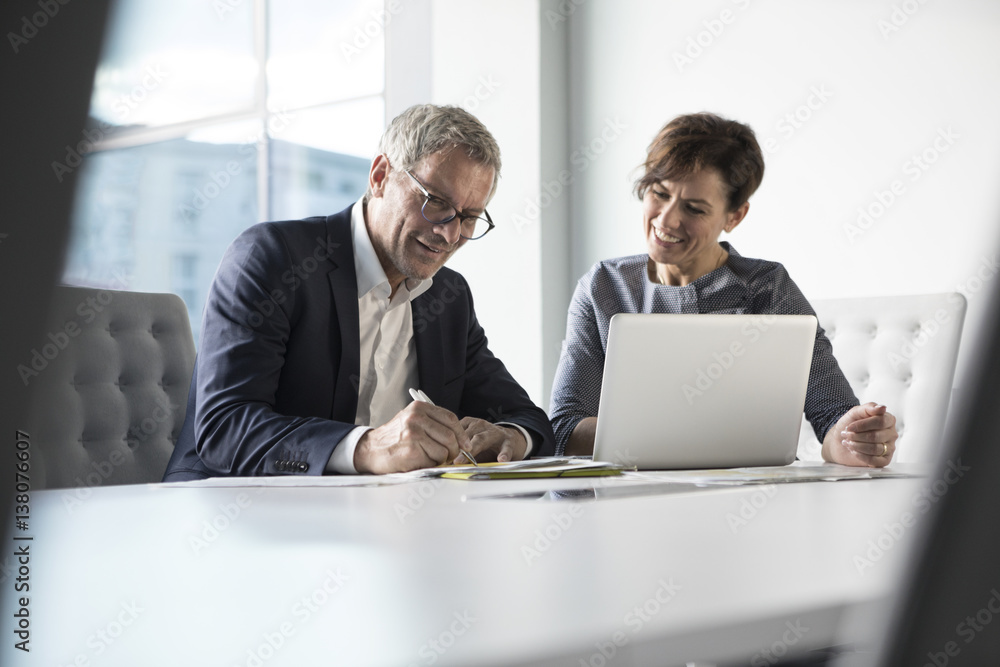 Businessman and businesswoman working together in office Businessman and businesswoman working together in office