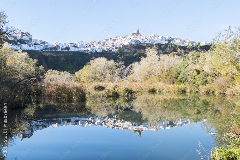 Panoramic of Arcos de la Frontera reflected in the river, white town built on a rock along Guadalete river, in the province of Cadiz, Spain Panoramic of Arcos de la Frontera reflected in the river, white town built on a rock along Guadalete river, in the province of Cadiz, Spain