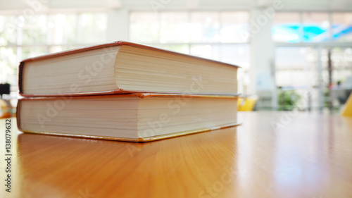 Book stack on wood desk in the library room with blurred focus for background  education back to school concept