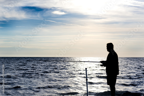 silhouette of fishermen at sunset on the sea beach © Italyteam