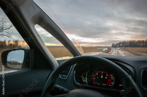 The view through car windscreen. Driving during sunset on the country road.