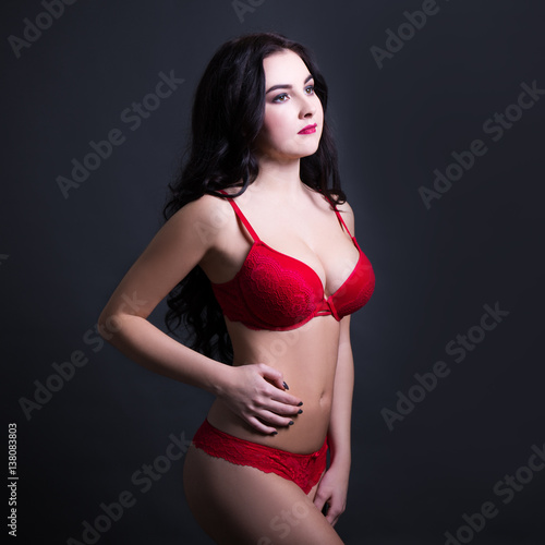 sexy young beautiful woman in red lace lingerie over black background © Di Studio
