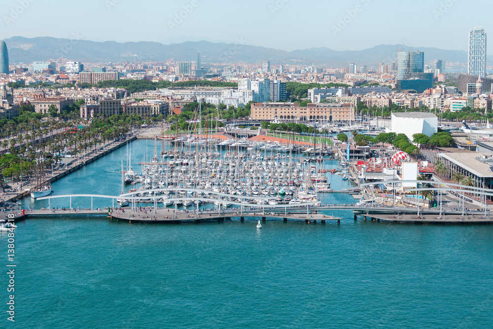 Port of Barcelona. Harbor with luxury yachts parked in the city center against the backdrop of urban development
