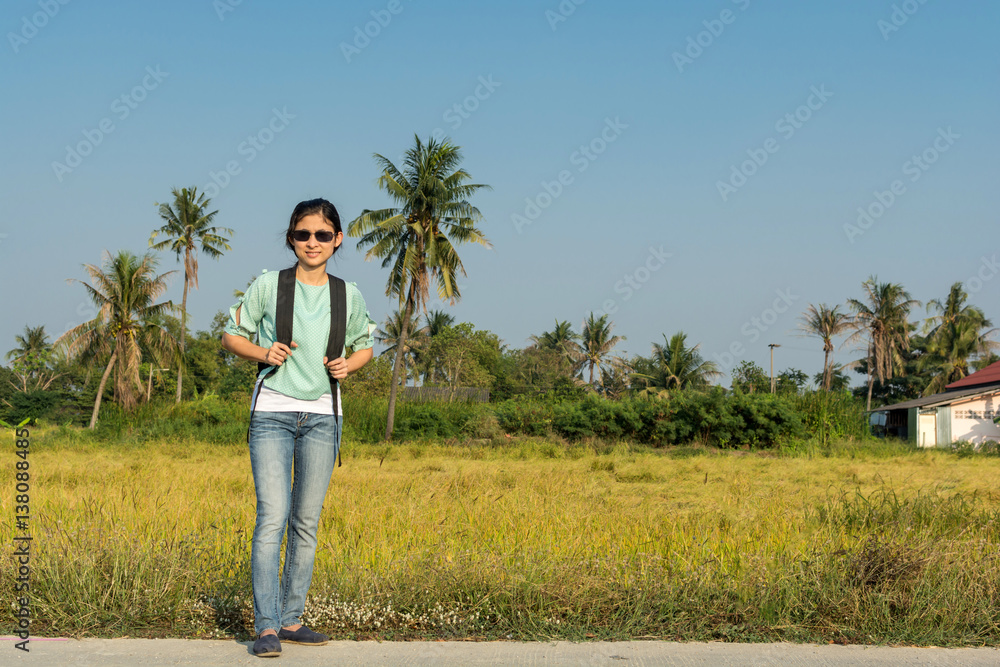 Young woman traveling among rice fields with backpack Young woman traveling among rice fields with backpack