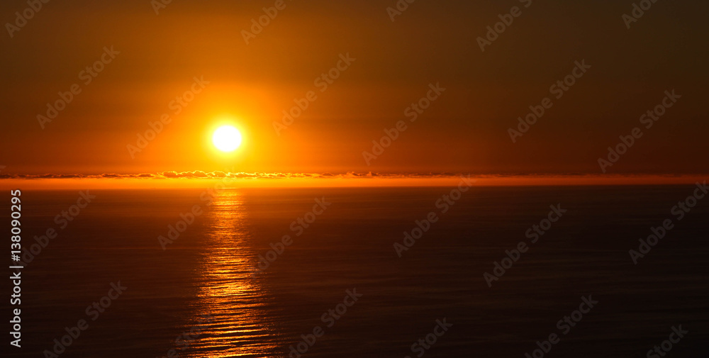 Sun setting over ocean