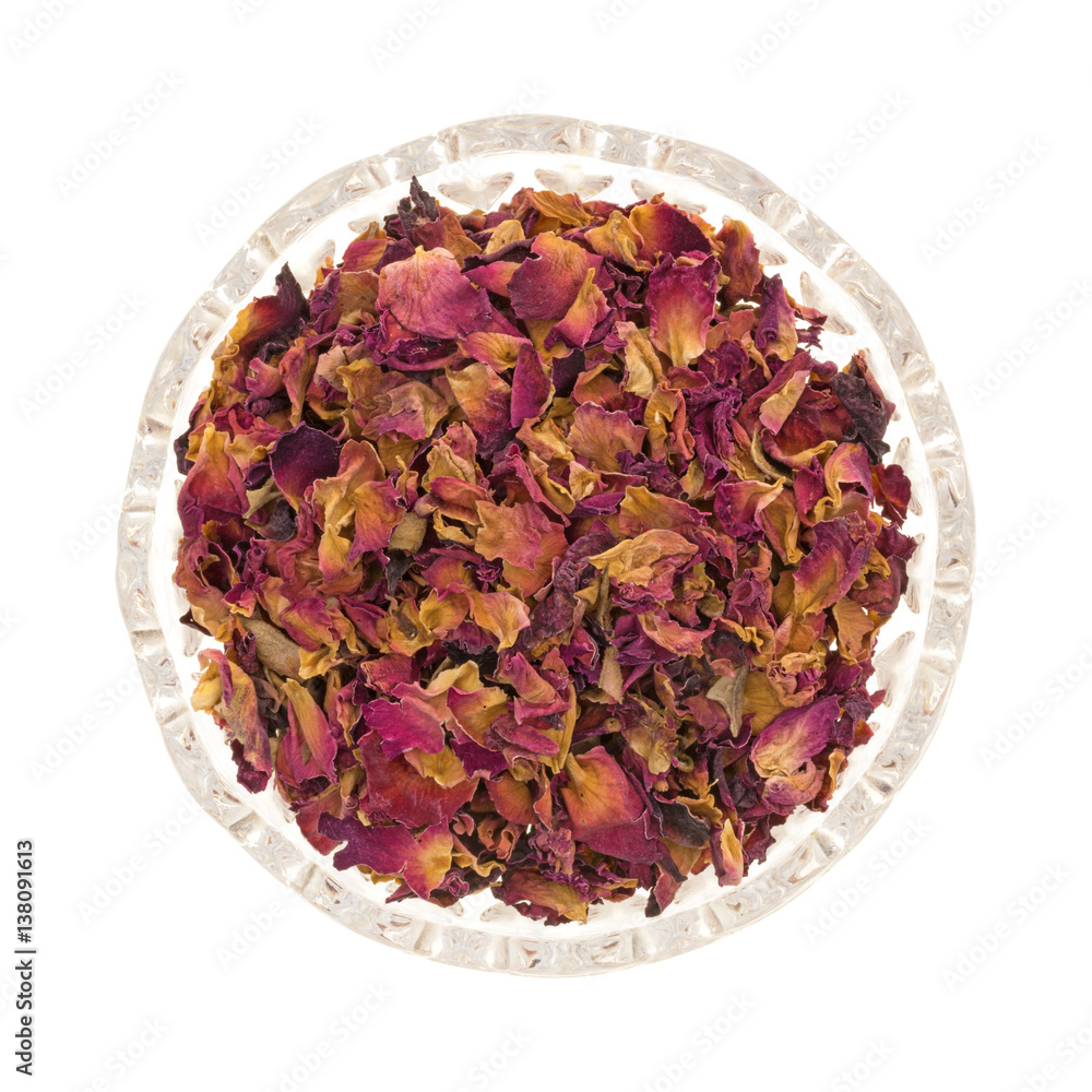 Top view of dried crushed red rosebuds and petals in a small bowl isolated on a white background. Top view of dried crushed red rosebuds and petals in a small bowl isolated on a white background.