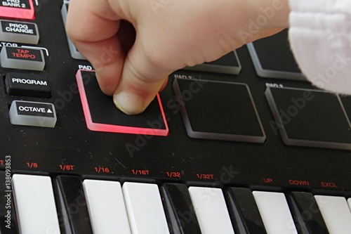 Obraz na plátně Small girl fingers hard pressing velocity sensitive sampler pad on MIDI controll