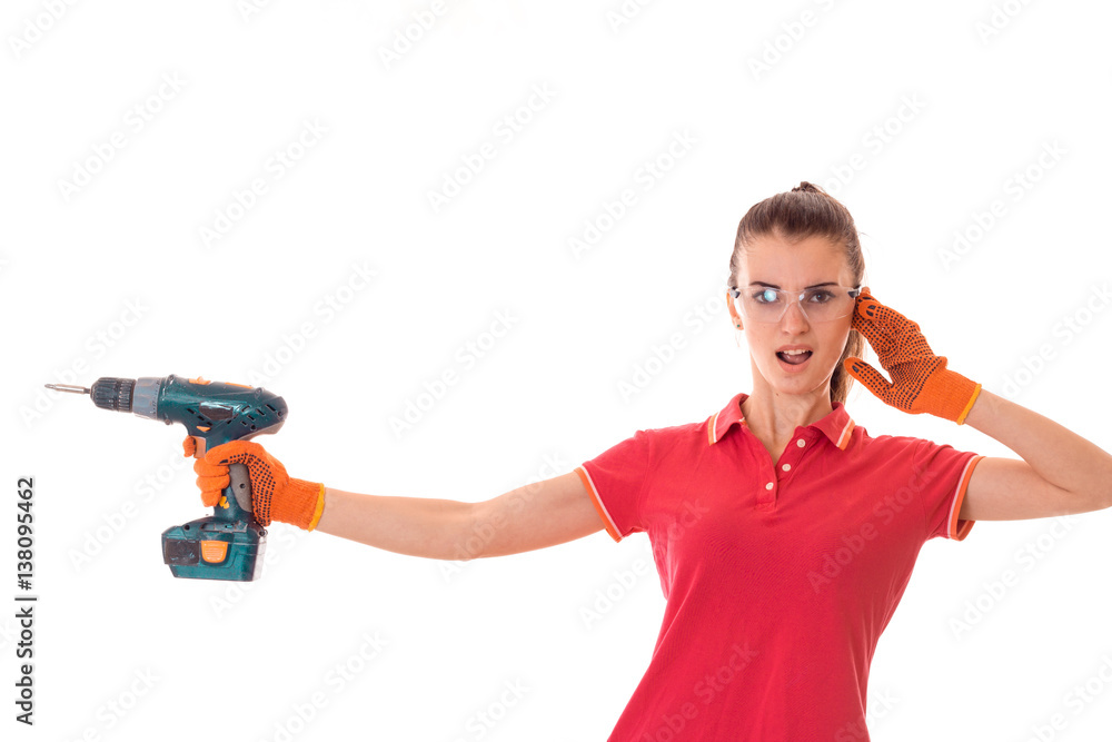 young funny brunette woman builder in uniform with glasses and drill in her hands make reovations isolated on white background young funny brunette woman builder in uniform with glasses and drill in her hands make reovations isolated on white background
