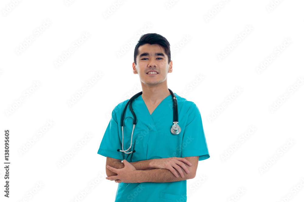 young happy brunette man doctor in blue uniform with stethoscope on his shoulders smiling on camera isolated on white background young happy brunette man doctor in blue uniform with stethoscope on his shoulders smiling on camera isolated on white background