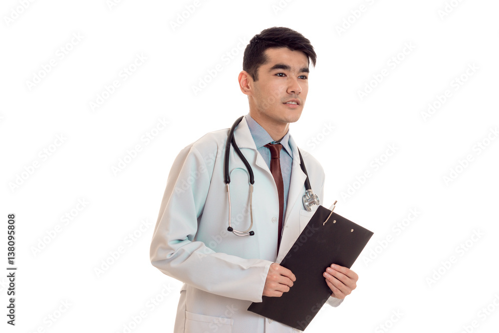 young sexy brunette man doctor in uniform with stethoscope on his shoulders make notes isolated on white background young sexy brunette man doctor in uniform with stethoscope on his shoulders make notes isolated on white background