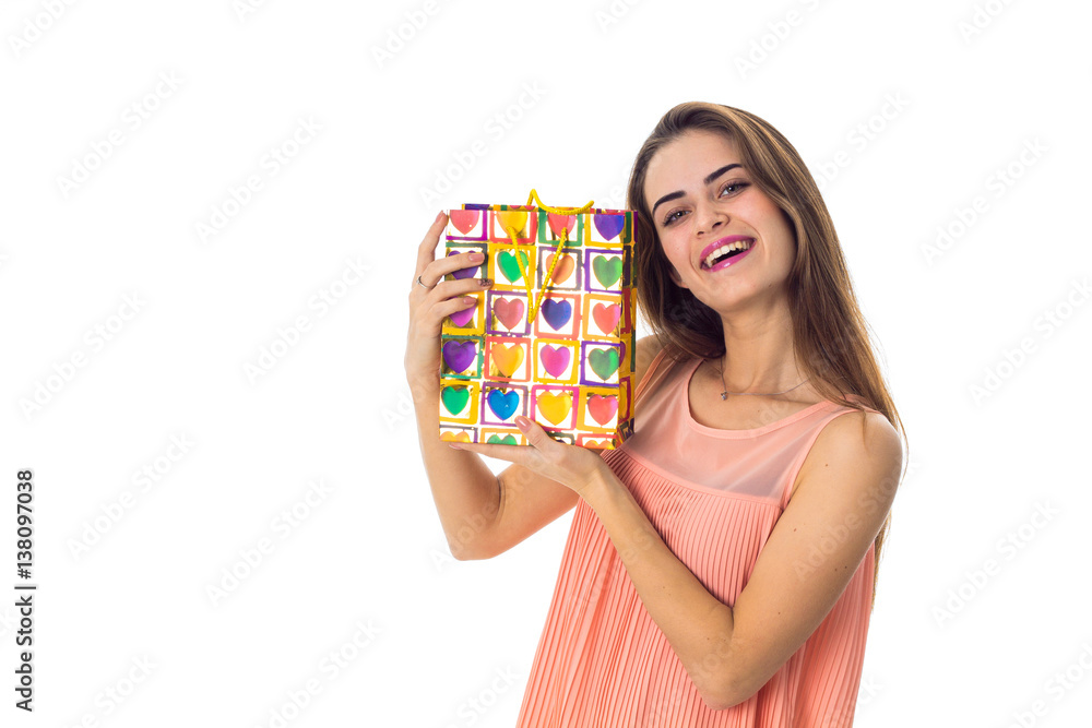 smiling girl holding a colored ear package isolated on white background smiling girl holding a colored ear package isolated on white background