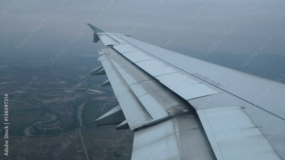 Video of a wing of airplane flying in the sky. Airplane decreases and aircraft flaps down - the view through the window. 4K stock footage.
Video of a wing of airplane flying in the sky. Airplane decreases and aircraft flaps down - the view through the window. 4K stock footage.