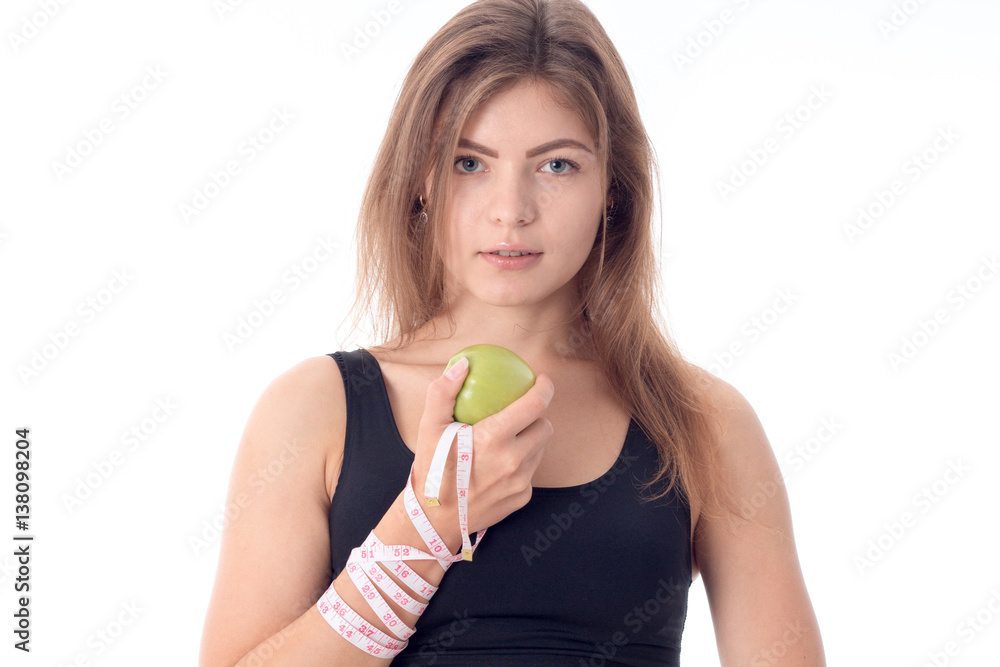 Young athletic girl standing sideways holding an apple in his hand Young athletic girl standing sideways holding an apple in his hand