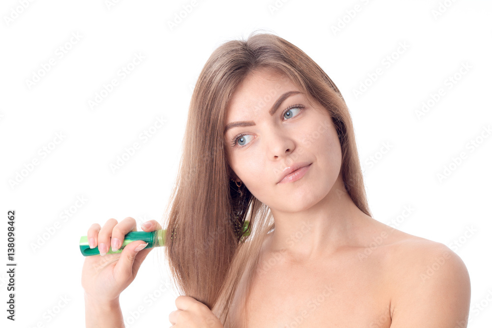 young girl looks away and combs her hair isolated on white background young girl looks away and combs her hair isolated on white background
