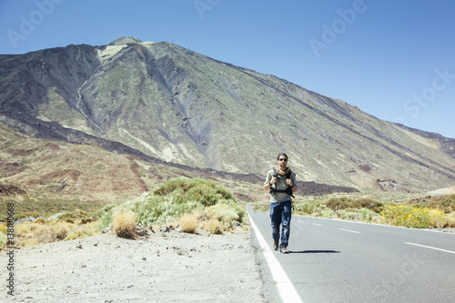 traveler man hitchhiking in Tenerife with the Teide on the background