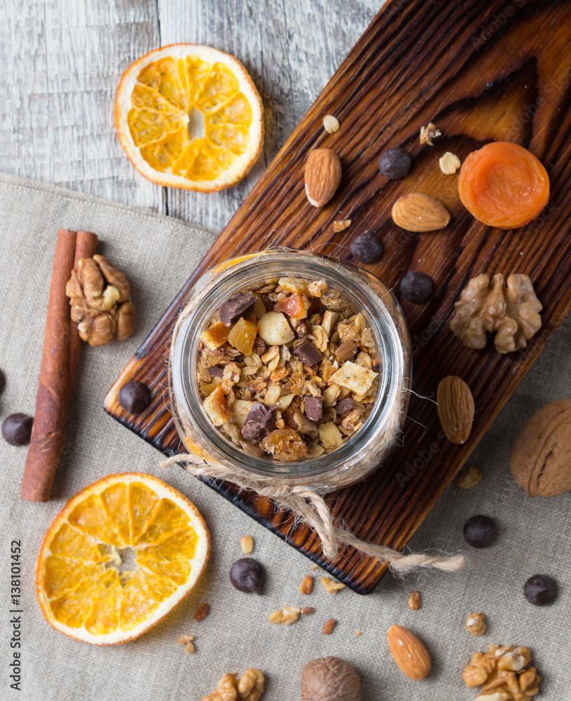 Homemade granola with nuts and dried oranges in jar with copy space, top view Homemade granola with nuts and dried oranges in jar with copy space, top view