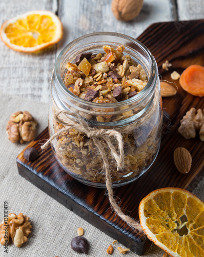 Homemade granola with nuts and dried oranges in jar