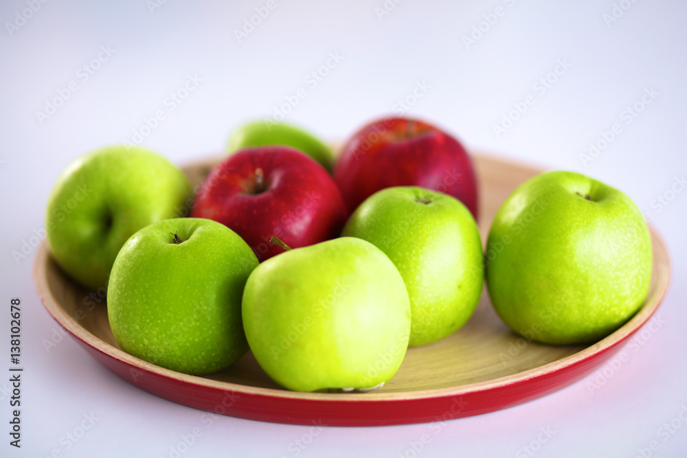 Still life arrangement of apples on a wooden platter Still life arrangement of apples on a wooden platter