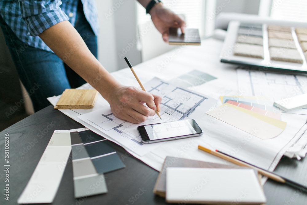 A young Asian man reviews renovation plans A young Asian man reviews renovation plans