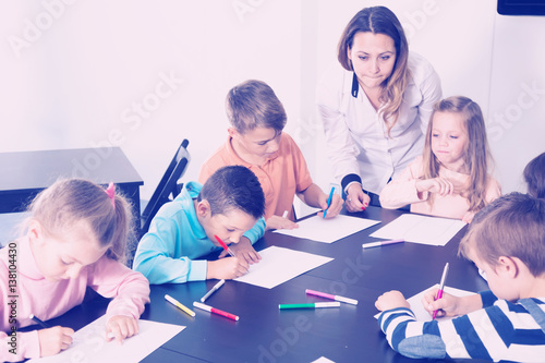 Professor and elementary age children drawing