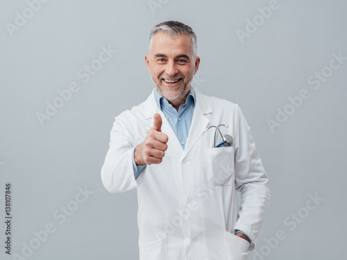 Cheerful doctor giving a thumbs up photo