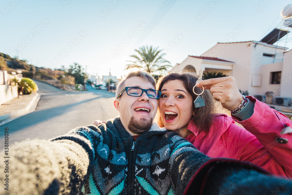 real estate: happy couple showing keys of their new house real estate: happy couple showing keys of their new house