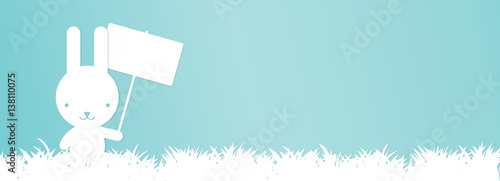Easter banner - Bunny holding an empty banner with copy space in grass, vector file