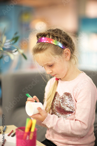 Girl in the common room of the museum draws felt pen on paper and cup photo