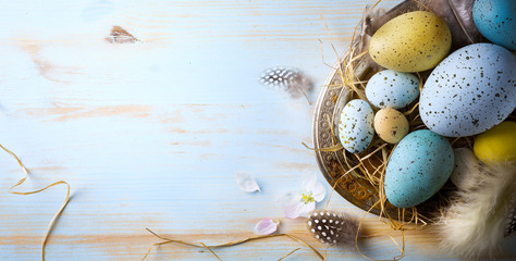 Easter background with Easter eggs and spring flowers. Top view with copy space