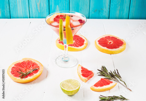 Refreshing homemade grapefruit and rosemary cocktail on white wooden table