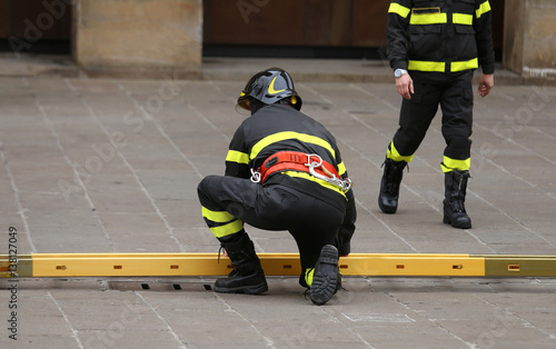 firemen during rescue operations with a wooden ladder