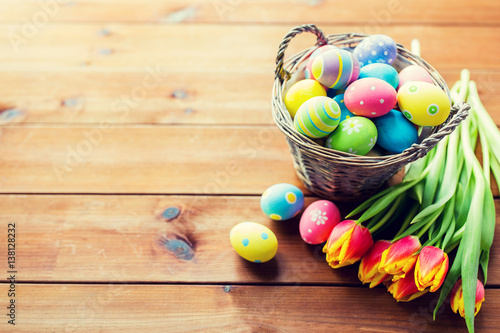 close up of easter eggs in basket and flowers
