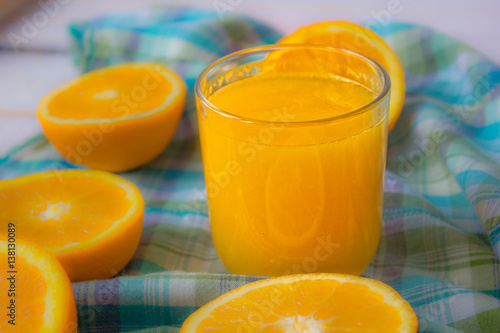 Glass of Orange Juice on white boards with orange halves